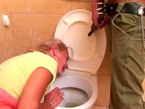 Una abuela rubia y voluminosa está arrodillada en el suelo chupando